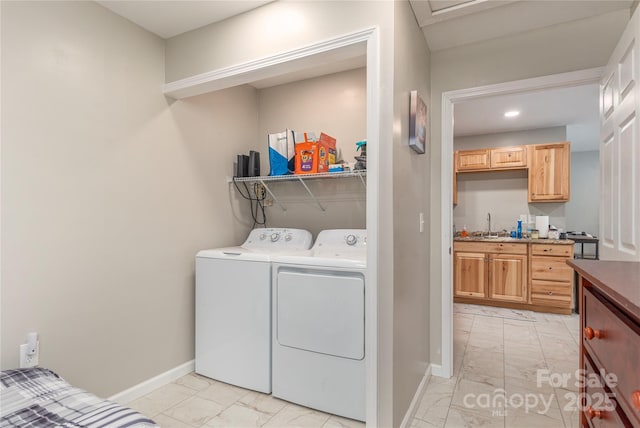 laundry area featuring marble finish floor, baseboards, washer and clothes dryer, and laundry area
