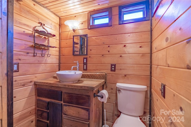 bathroom featuring wood walls, vanity, wood ceiling, and toilet