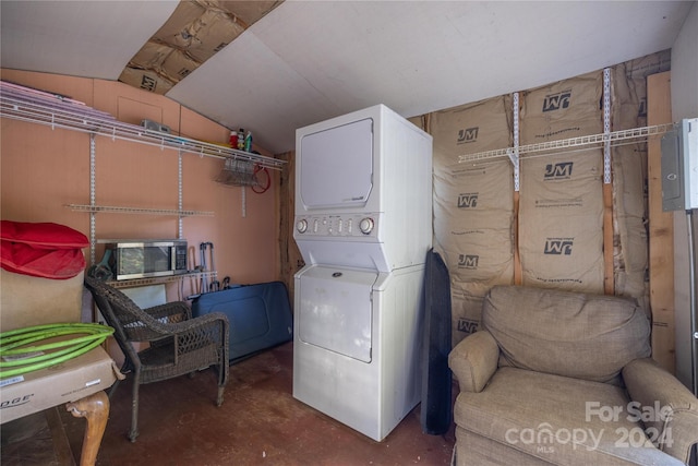 clothes washing area featuring stacked washer and dryer