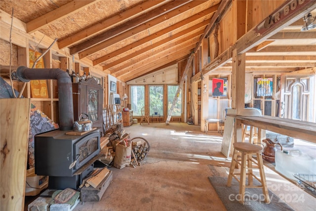 miscellaneous room featuring a wood stove and vaulted ceiling