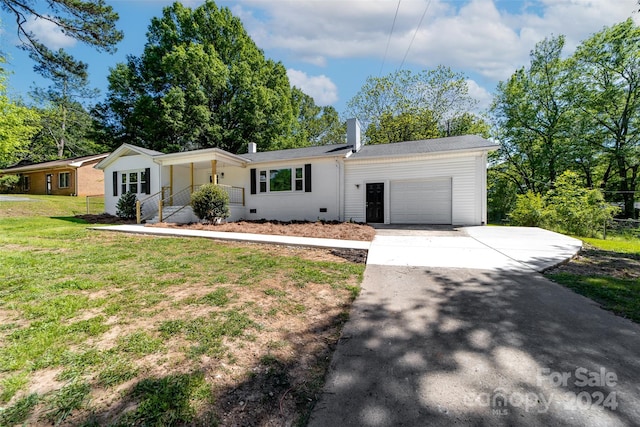 ranch-style house featuring a garage and a front lawn