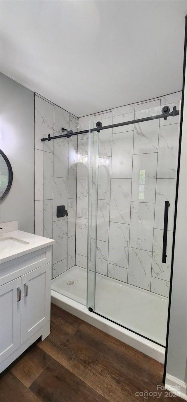 bathroom featuring vanity, an enclosed shower, and wood-type flooring