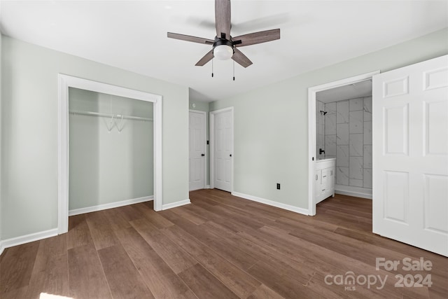 unfurnished bedroom featuring ensuite bathroom, hardwood / wood-style flooring, and ceiling fan