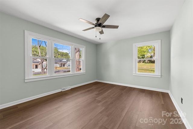 empty room with wood-type flooring, plenty of natural light, and ceiling fan