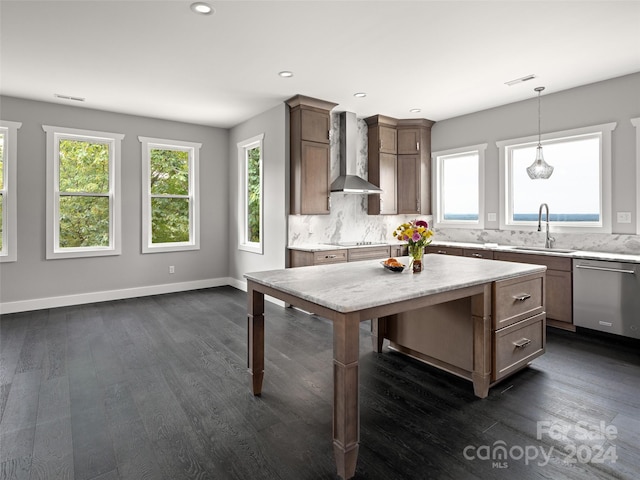 kitchen featuring decorative backsplash, stainless steel dishwasher, dark wood-type flooring, and wall chimney range hood