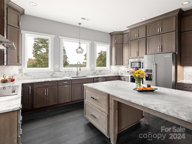 kitchen featuring backsplash, stainless steel appliances, dark wood-type flooring, sink, and pendant lighting