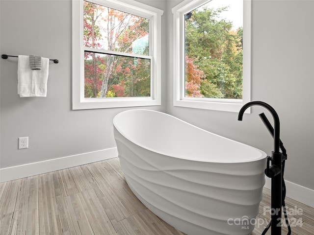 bathroom featuring hardwood / wood-style floors and a bath