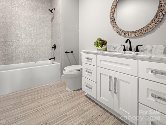 full bathroom featuring toilet, hardwood / wood-style floors, vanity, and tiled shower / bath