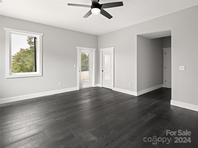 unfurnished room featuring ceiling fan, dark hardwood / wood-style flooring, and plenty of natural light