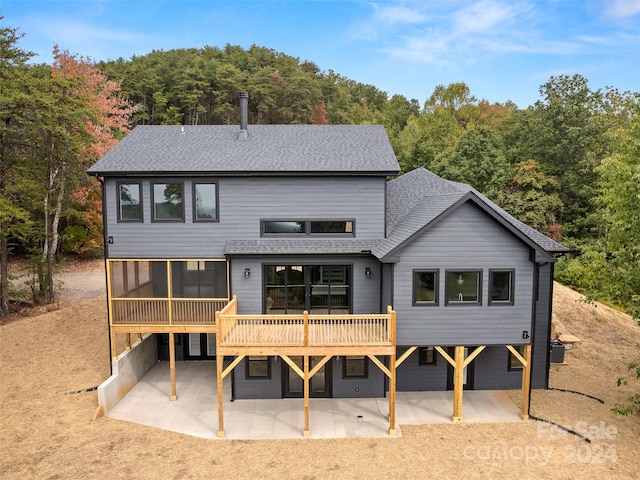 back of house featuring a sunroom, a patio area, and a wooden deck