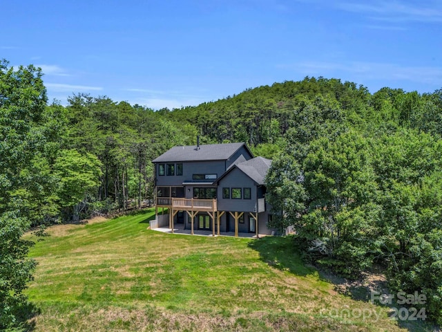 view of front of house with a wooden deck and a front lawn