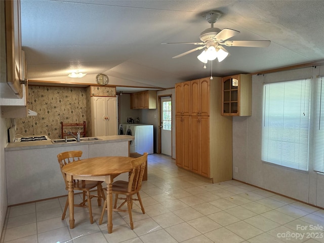 dining space with a textured ceiling, ceiling fan, washing machine and clothes dryer, light tile patterned floors, and sink