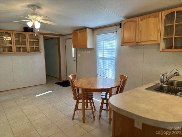 dining space with light tile patterned flooring, sink, and ceiling fan