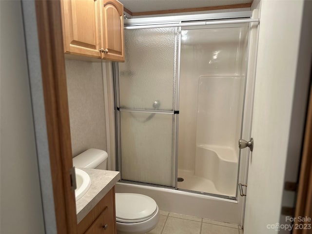 bathroom with toilet, vanity, and tile patterned flooring