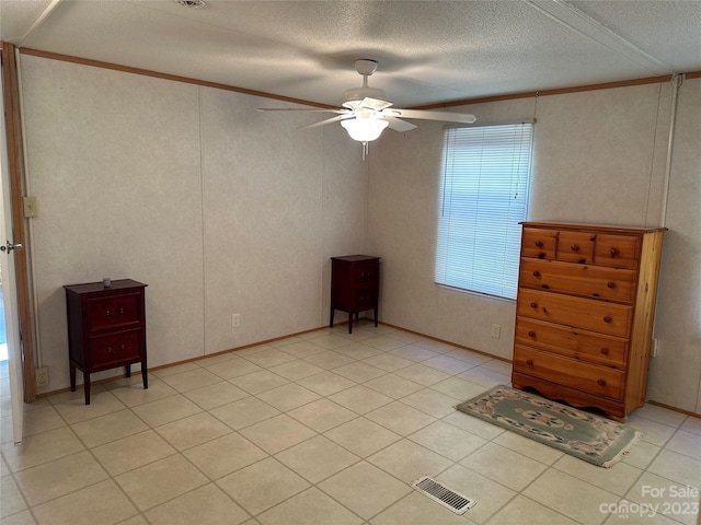 interior space featuring ceiling fan, a textured ceiling, and ornamental molding