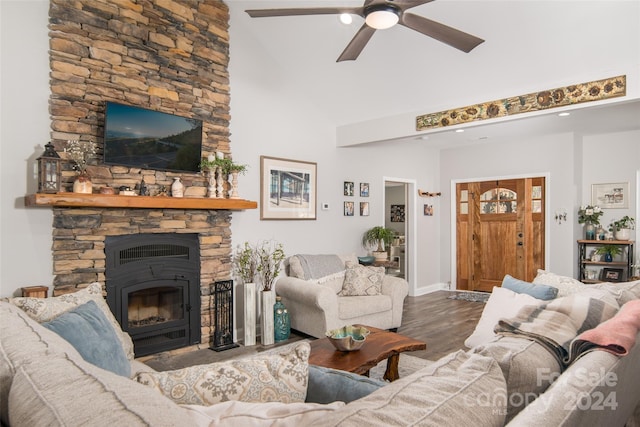 living room with dark hardwood / wood-style floors, a fireplace, ceiling fan, and a high ceiling