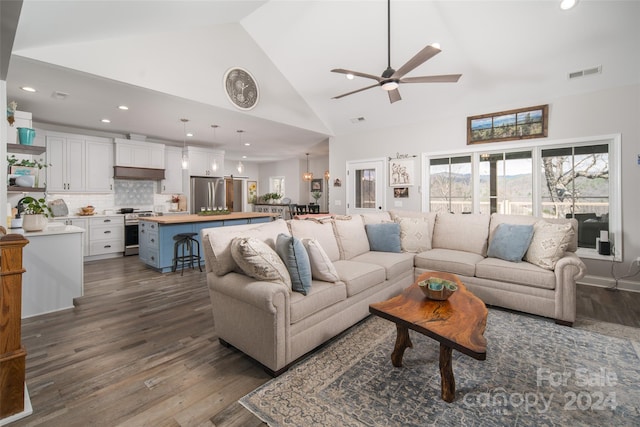 living room with high vaulted ceiling, ceiling fan, and dark wood-type flooring