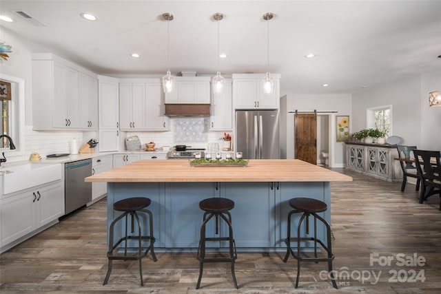 kitchen featuring a kitchen breakfast bar, stainless steel appliances, a center island, and a barn door