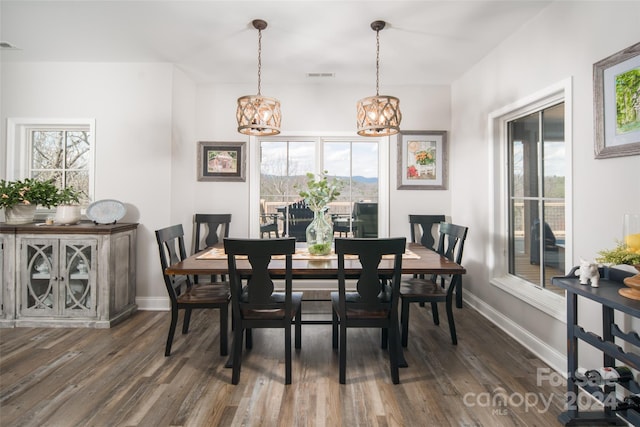 dining room with dark wood-type flooring and an inviting chandelier