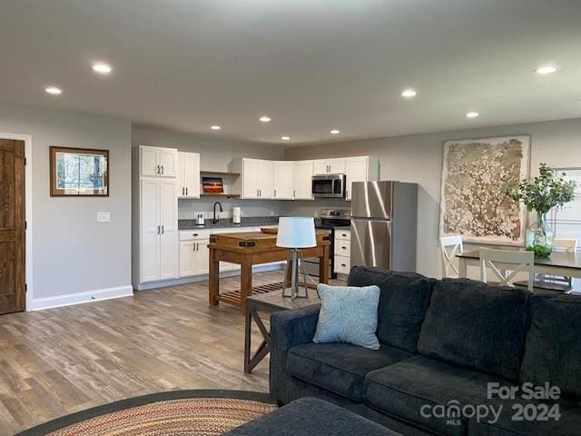 living room featuring sink and light hardwood / wood-style floors