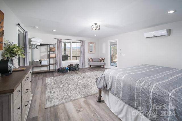 bedroom with dark hardwood / wood-style floors and a wall mounted AC