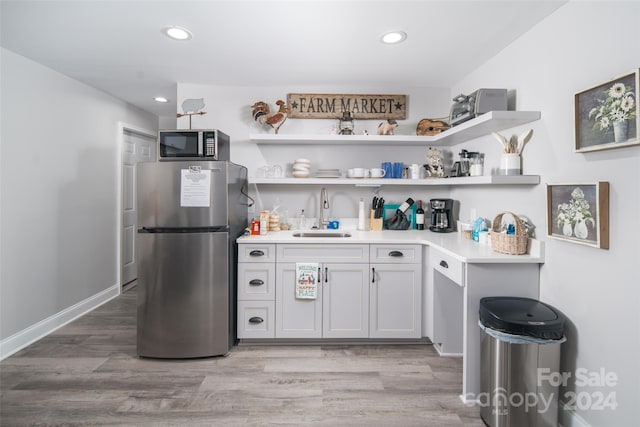 kitchen featuring white cabinets, sink, light hardwood / wood-style flooring, and stainless steel appliances