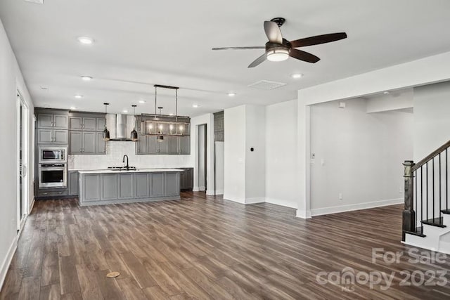 unfurnished living room with dark hardwood / wood-style flooring, ceiling fan, and sink