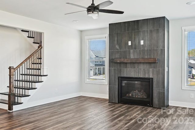 unfurnished living room featuring dark hardwood / wood-style flooring, a fireplace, and a wealth of natural light