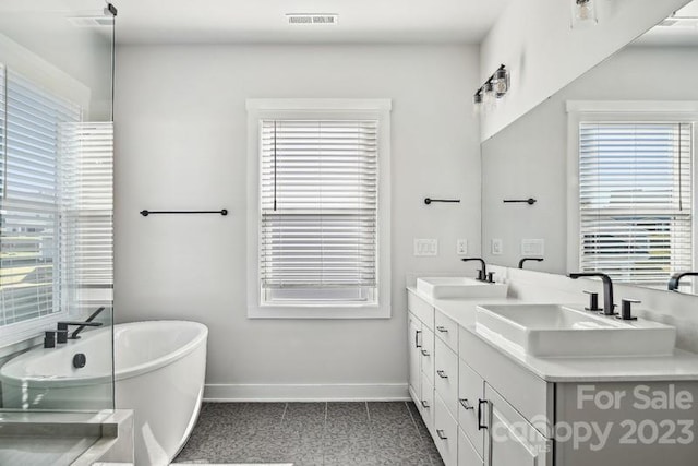 bathroom with plenty of natural light, dual bowl vanity, and tile floors