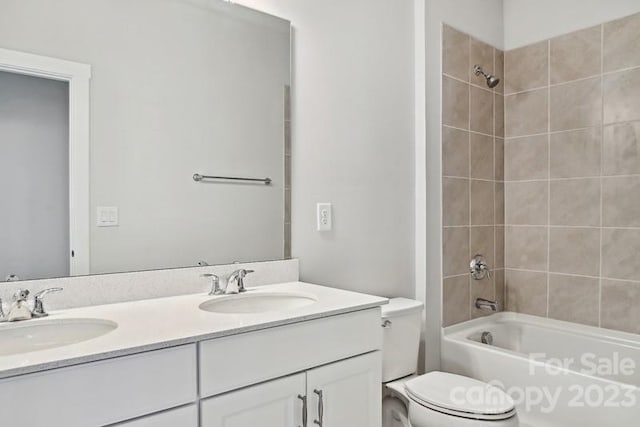 full bathroom featuring tiled shower / bath, toilet, and double vanity