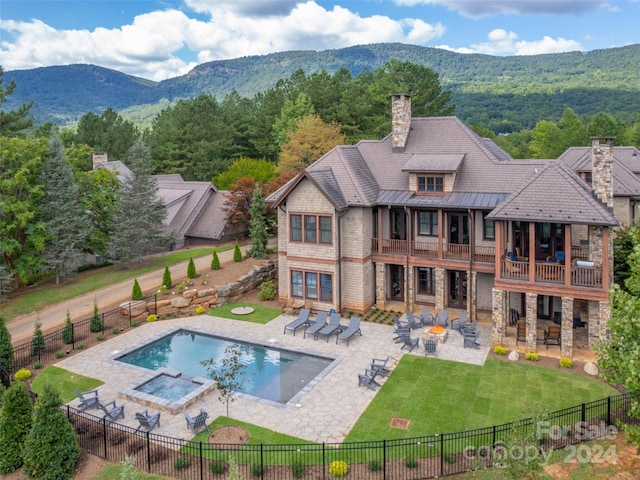 view of swimming pool with a lawn, a mountain view, and a patio