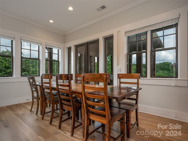 dining space featuring light hardwood / wood-style floors and ornamental molding