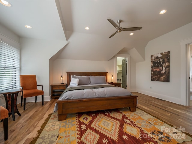 bedroom with ceiling fan, vaulted ceiling, and light wood-type flooring