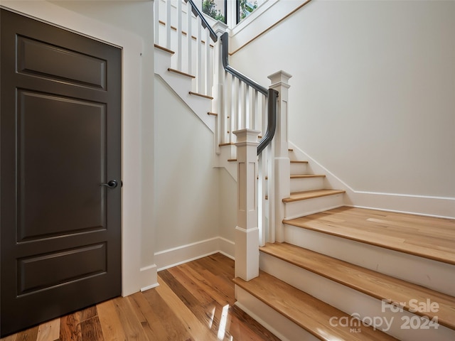 staircase with hardwood / wood-style floors