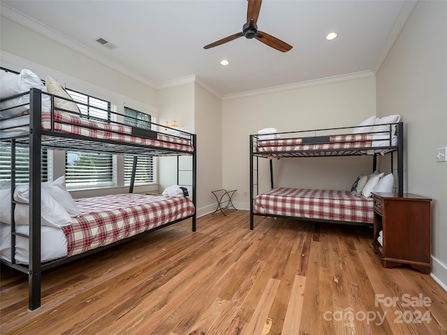 bedroom with ceiling fan, ornamental molding, and wood-type flooring