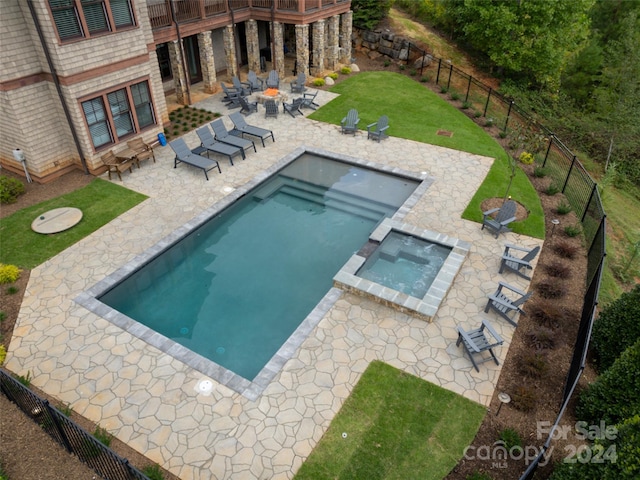 view of swimming pool featuring a patio area, an in ground hot tub, and a yard