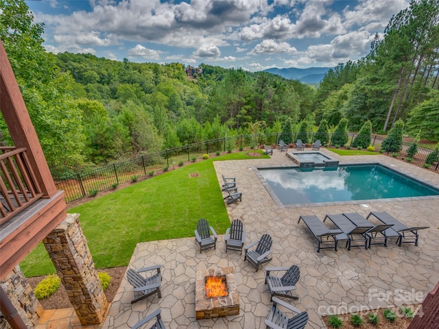 view of pool featuring a patio, a fire pit, a yard, and an in ground hot tub