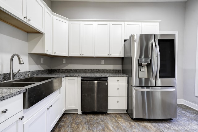 kitchen with dark stone counters, dishwashing machine, white cabinetry, stainless steel refrigerator with ice dispenser, and sink