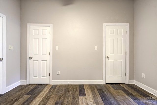 unfurnished bedroom with dark hardwood / wood-style flooring