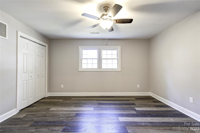 unfurnished bedroom featuring a closet, ceiling fan, and dark hardwood / wood-style flooring