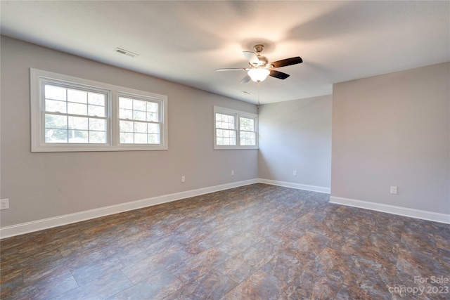 empty room featuring dark tile flooring and ceiling fan