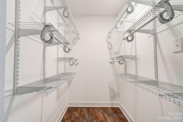 spacious closet featuring dark tile floors