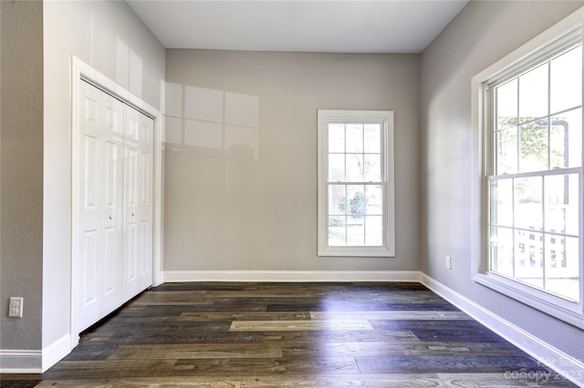 unfurnished bedroom featuring a closet and dark wood-type flooring