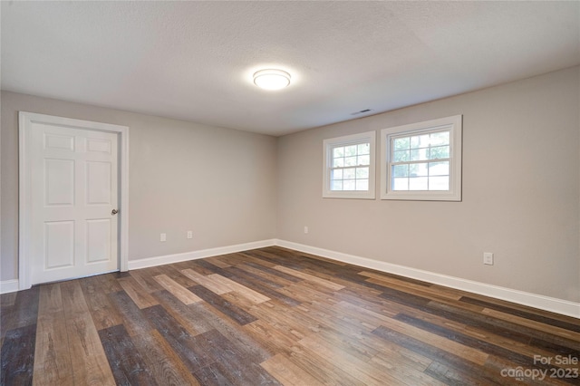 unfurnished room with dark hardwood / wood-style floors