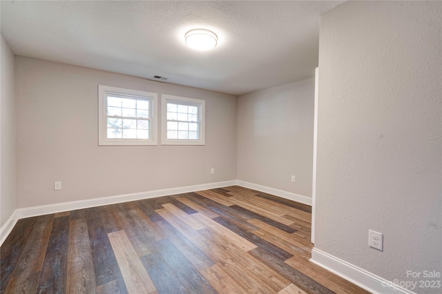 spare room featuring dark wood-type flooring