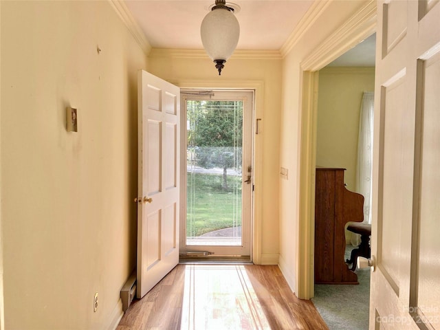 entryway with light hardwood / wood-style flooring, ornamental molding, and a healthy amount of sunlight