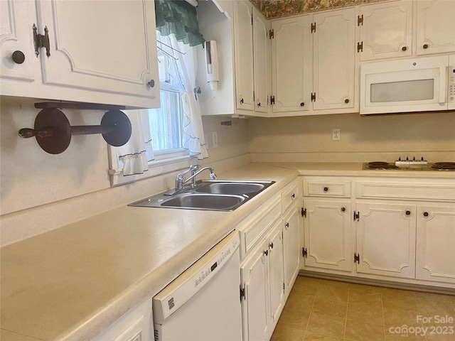 kitchen with white cabinets, white appliances, sink, and light tile floors