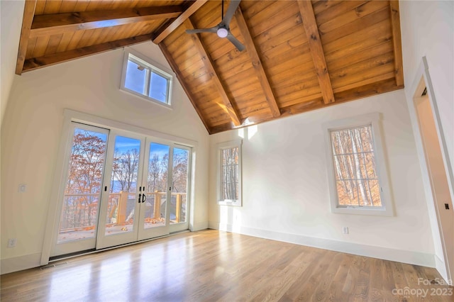 empty room with high vaulted ceiling, light wood-type flooring, beam ceiling, ceiling fan, and wood ceiling