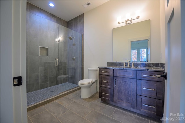 bathroom featuring a shower with door, tile flooring, oversized vanity, and toilet