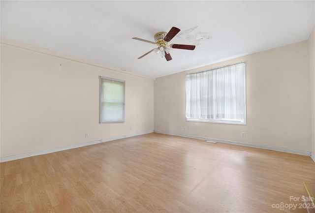 unfurnished room featuring light hardwood / wood-style floors, ceiling fan, and a healthy amount of sunlight